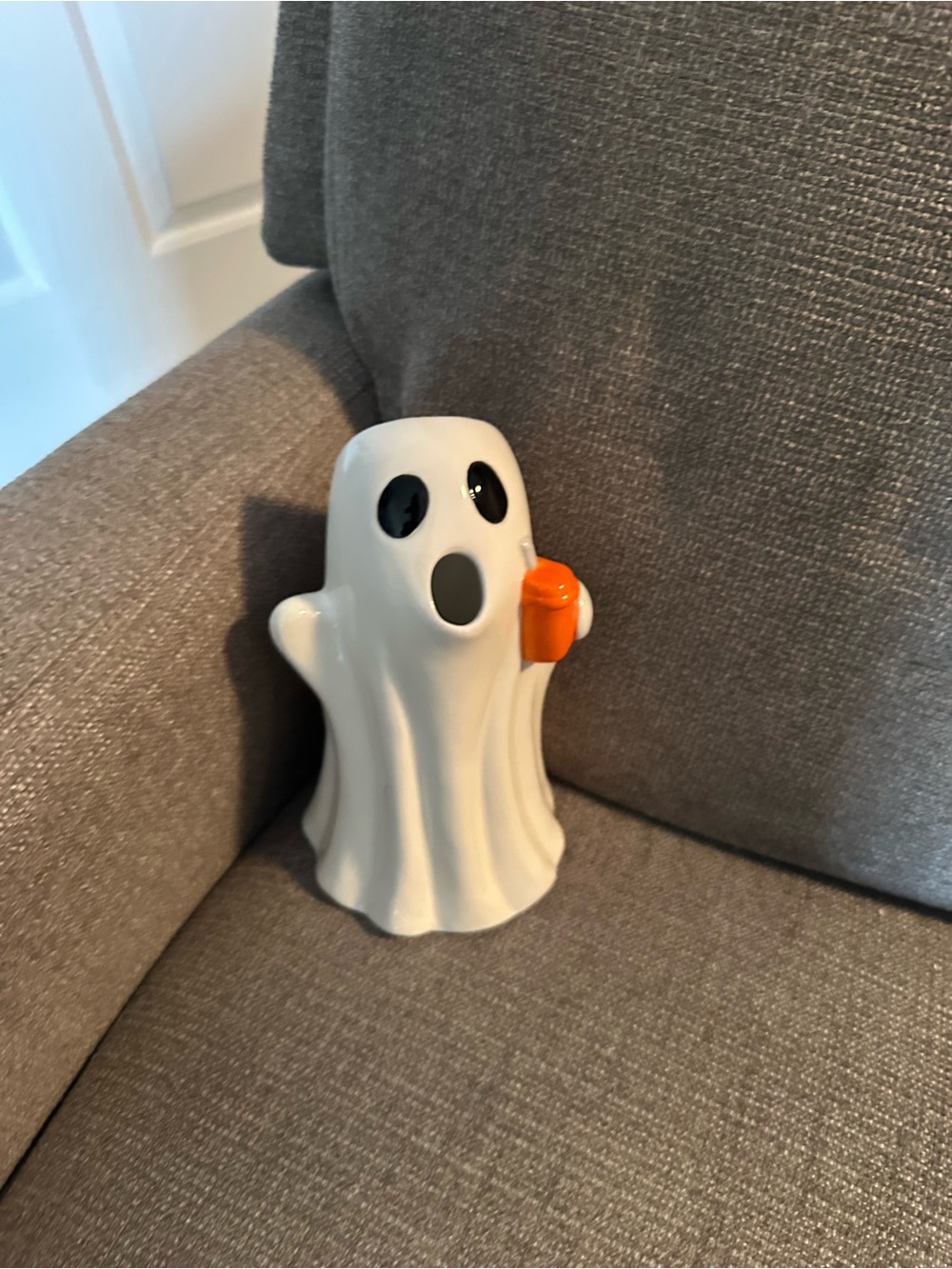 White Ceramic Ghost Figurine with Orange Pumpkin Accent